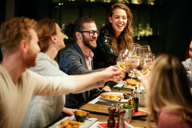 Friends enjoying dinner and drinks at a restaurant near Madison Laurel Oaks in North Raleigh, NC