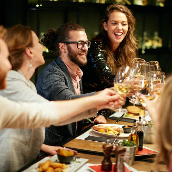 Friends enjoying dinner and drinks at a restaurant near Madison Laurel Oaks in North Raleigh, NC
