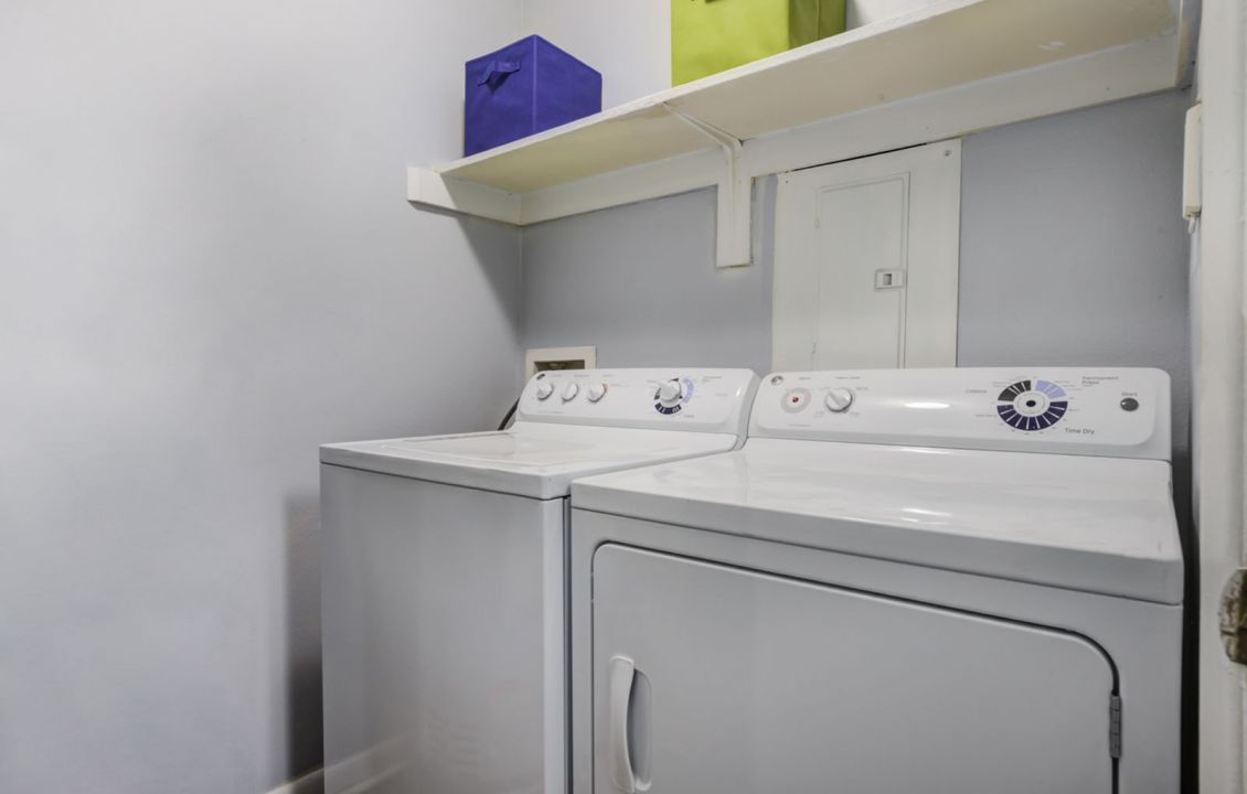 In-unit washer and dryer with storage shelf and cabinetry at Madison Laurel Oaks apartments in North Raleigh, NC
