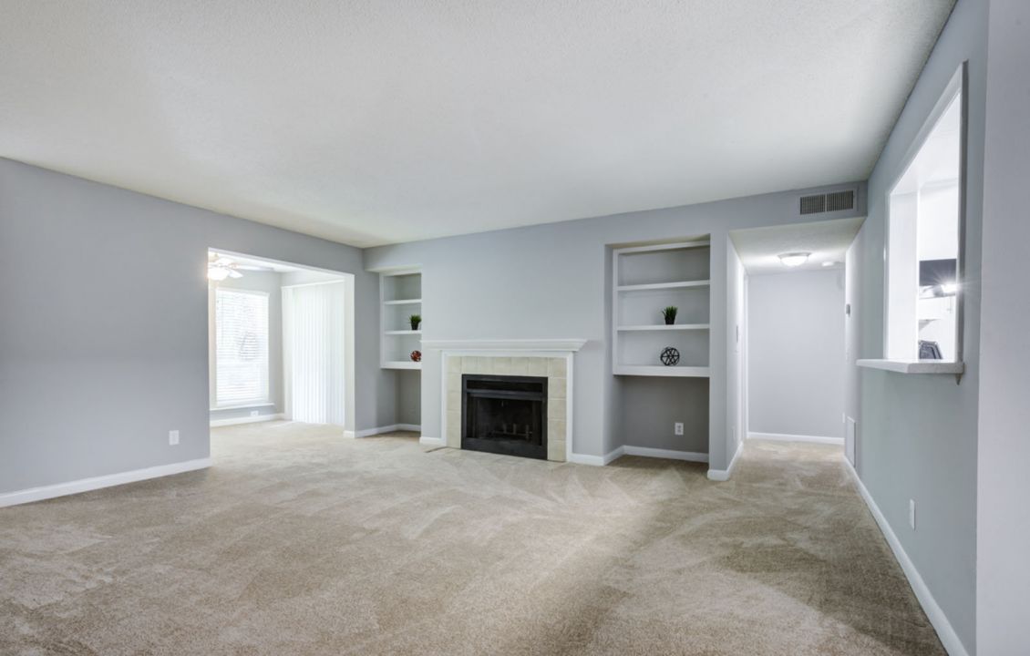 Living area featuring wood-burning fireplace and built-in bookshelves at Madison Laurel Oaks apartments in North Raleigh, NC